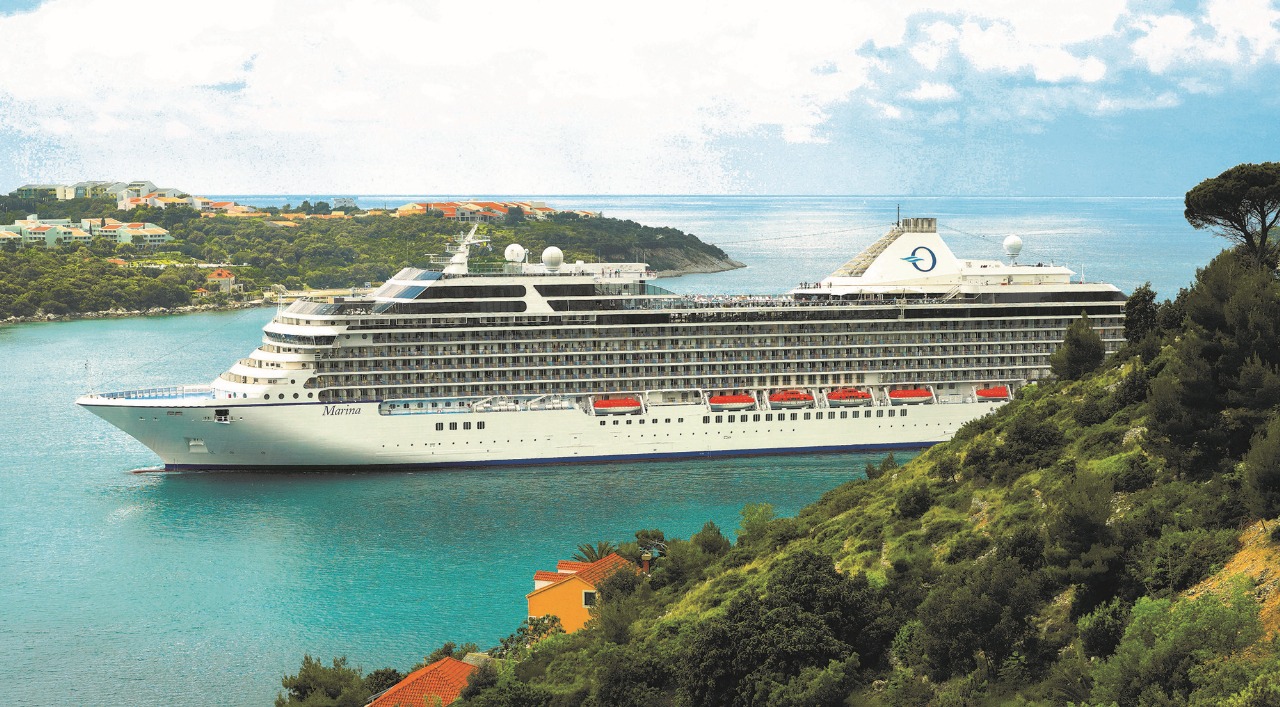 Cruise ship sailing near a Mediterranean coast